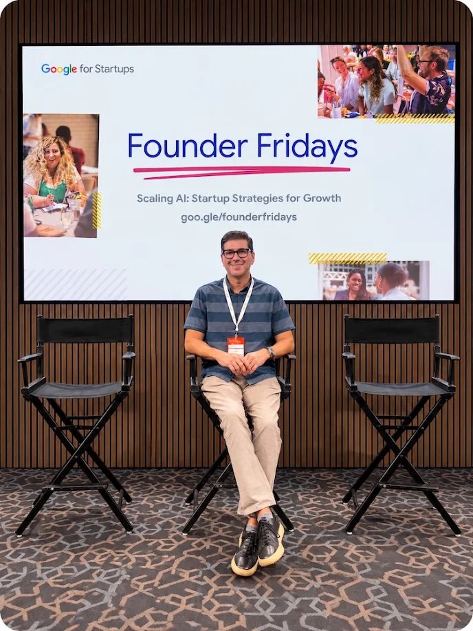 Speaker seated on stage at Google for Startups Founder Fridays, in front of a screen reading "Scaling AI: Startup Strategies for Growth"